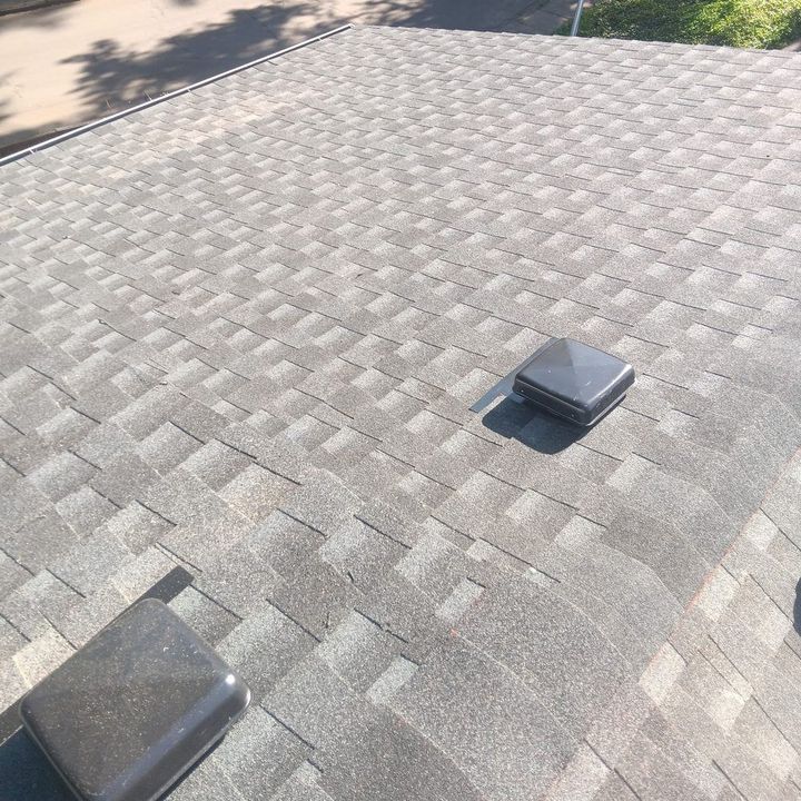 After: the finished grey shingle roof the next day, looking down toward the street